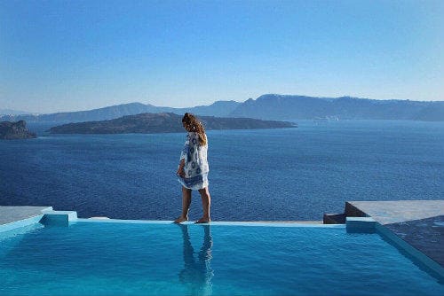 Tudo sobre a Eurail | Menina andando ao lado da piscina em Santorini, Grécia